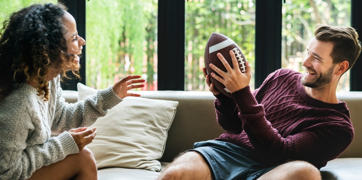 man and woman playing football indoors