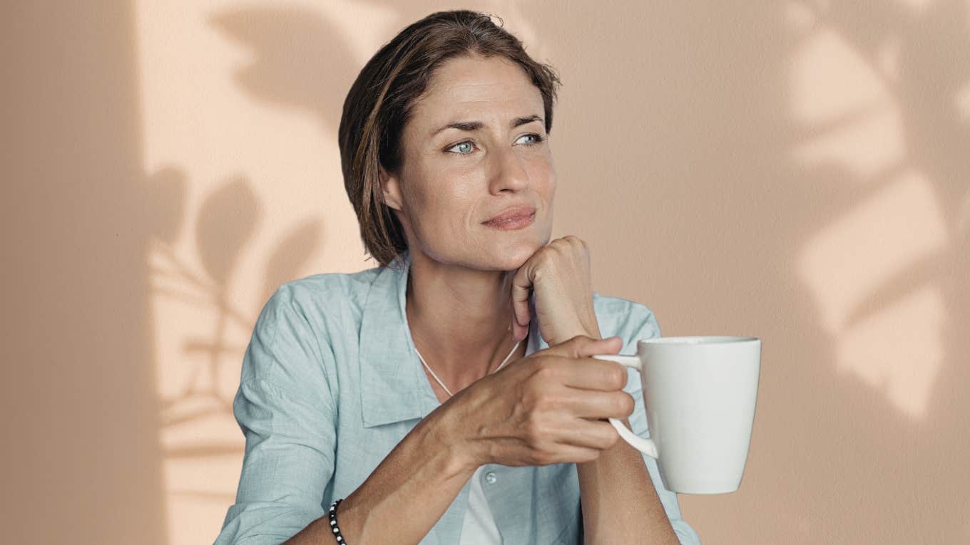 Woman looking introspective with a coffee mug. 