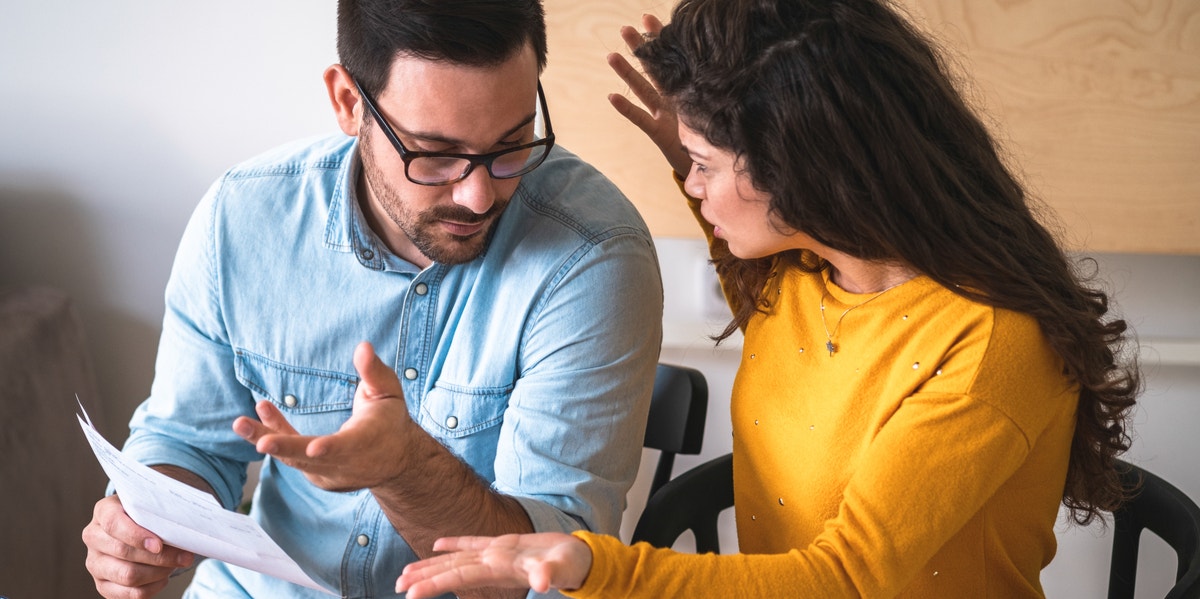 3 Reasons Why Married Couples Argue About Money (Even When They're Happy) couple arguing over bills