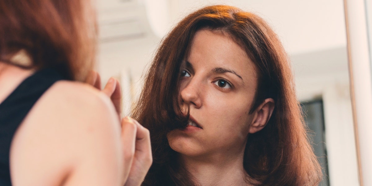 overwhelmed woman looking in the mirror