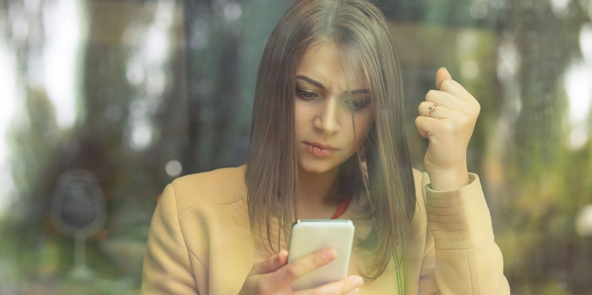 woman through a window looking at phone