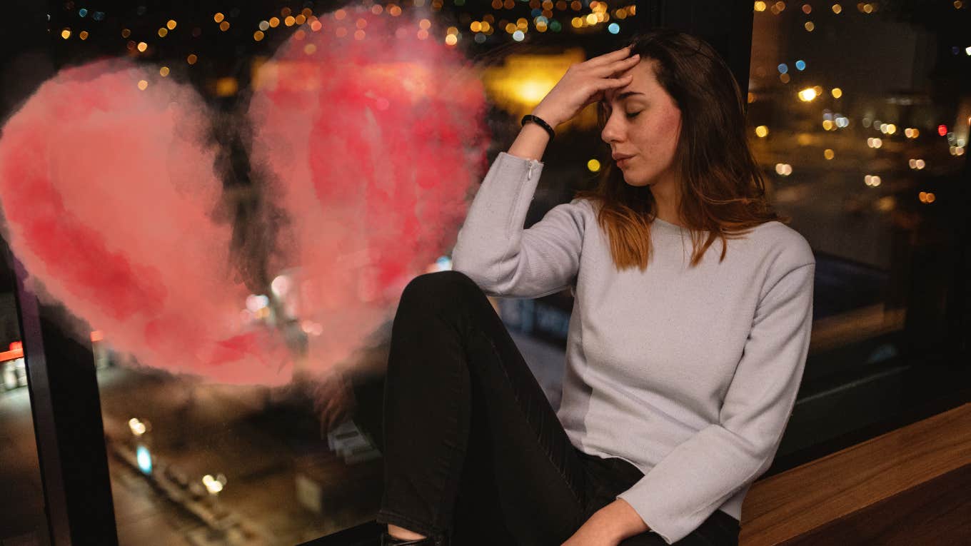 Girl sitting by window upset 