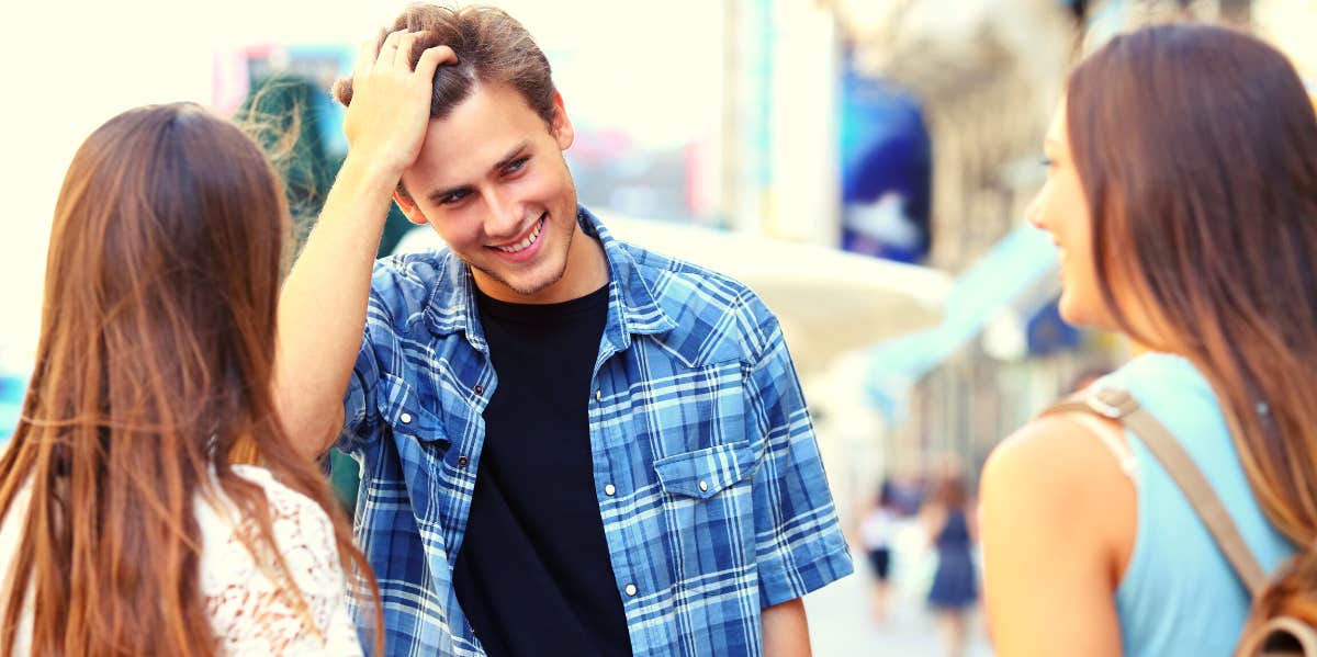 smiling man talking to two women