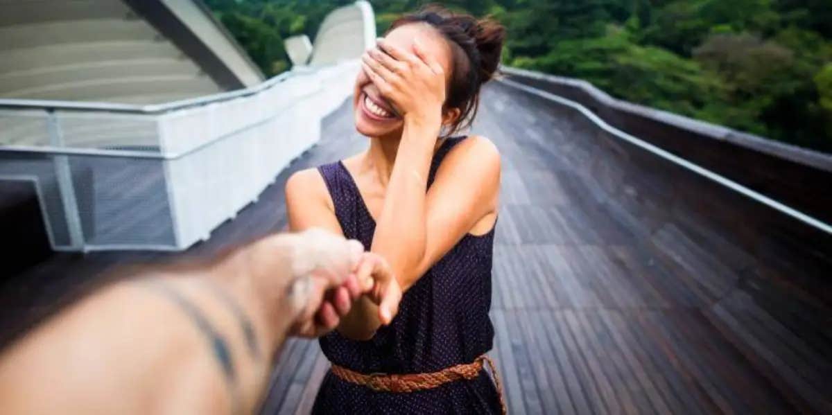 smiling woman covering her face with her hand in embarrassment