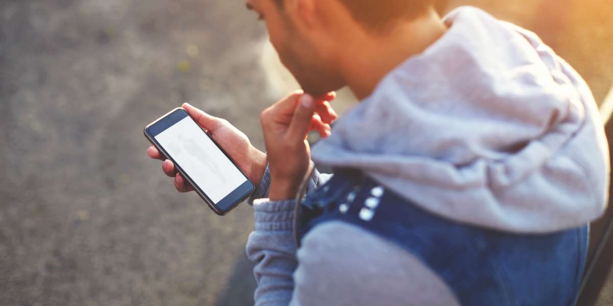 guy wondering how to tell if a girl likes you over text while looking at his phone