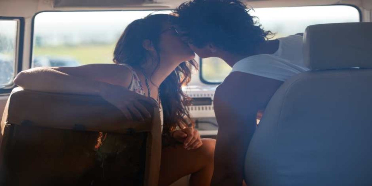 man and woman kissing in a car