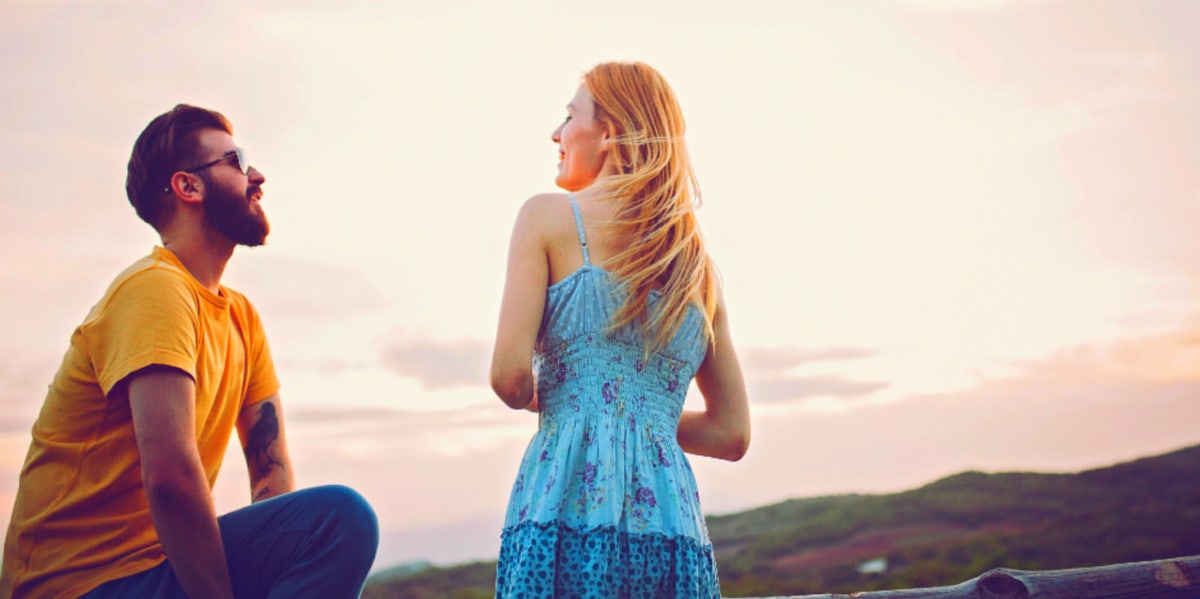 man and woman standing looking at each other smiling