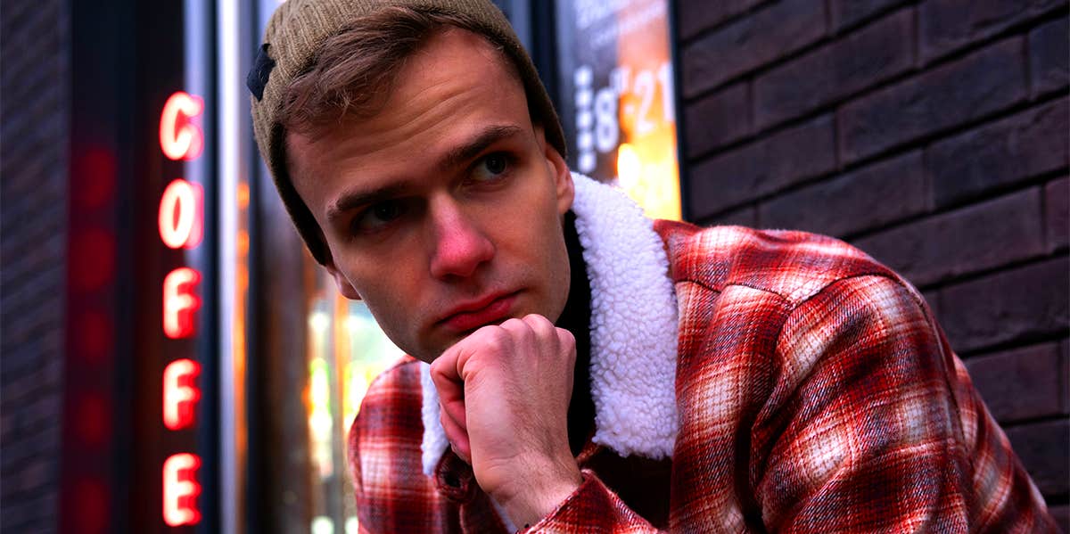Harsh Reason Women Get Played By The Men They Date man wearing flannel and beanie outside coffee shop