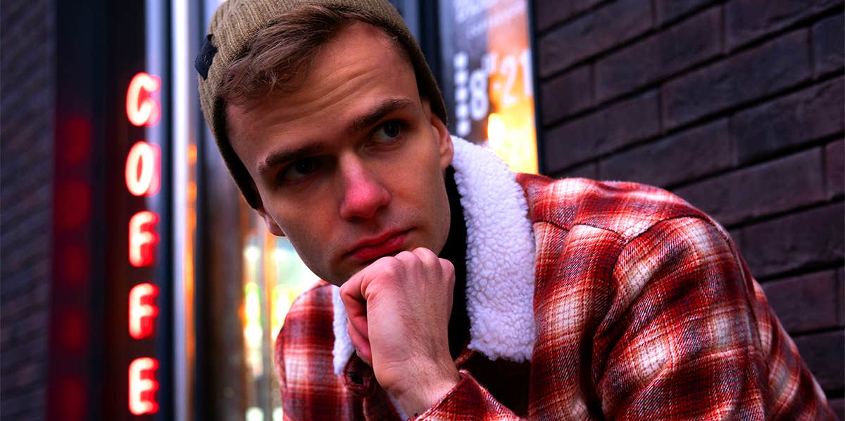 man wearing flannel and beanie outside coffee shop