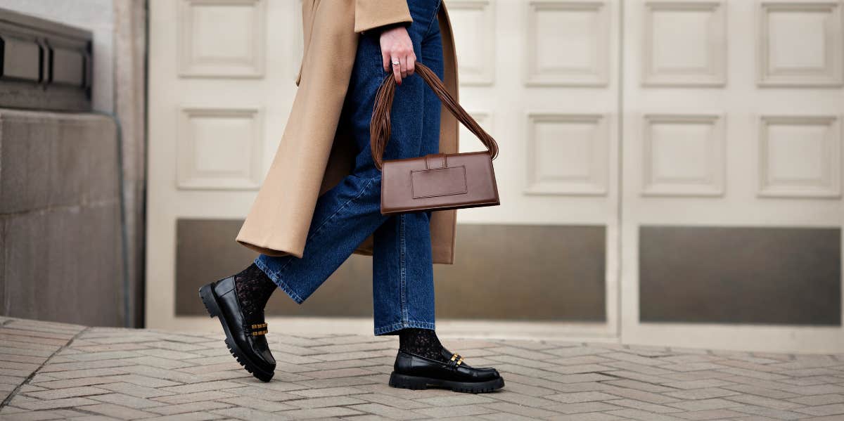 woman carrying purse on sidewalk 