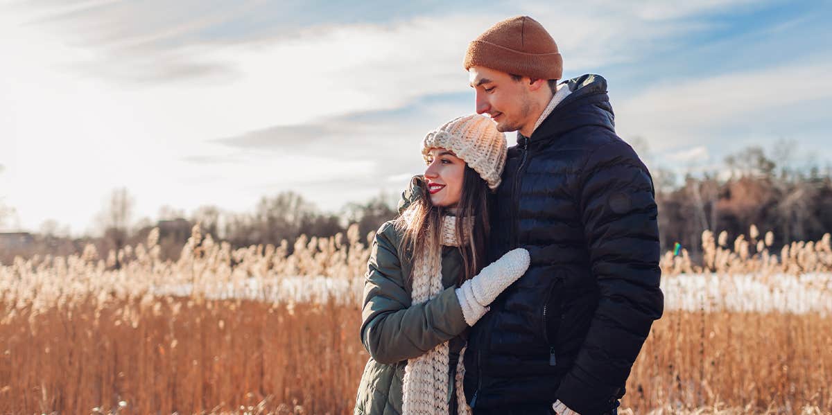 woman hugging man in field