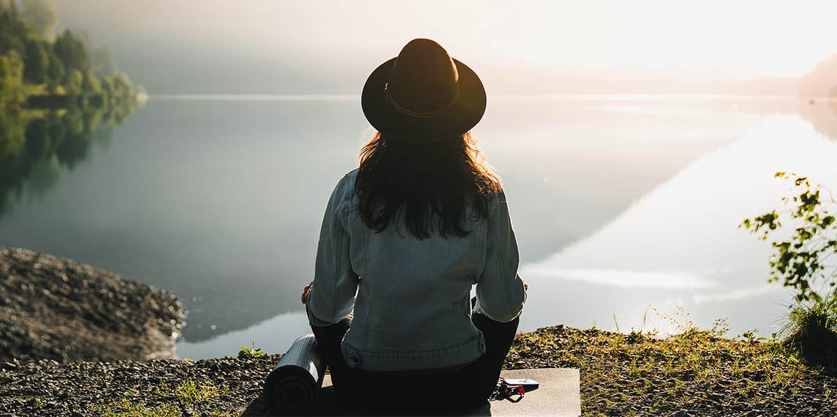 Problematic myths about spirituality that keep you miserable woman sitting enjoying view of ocean