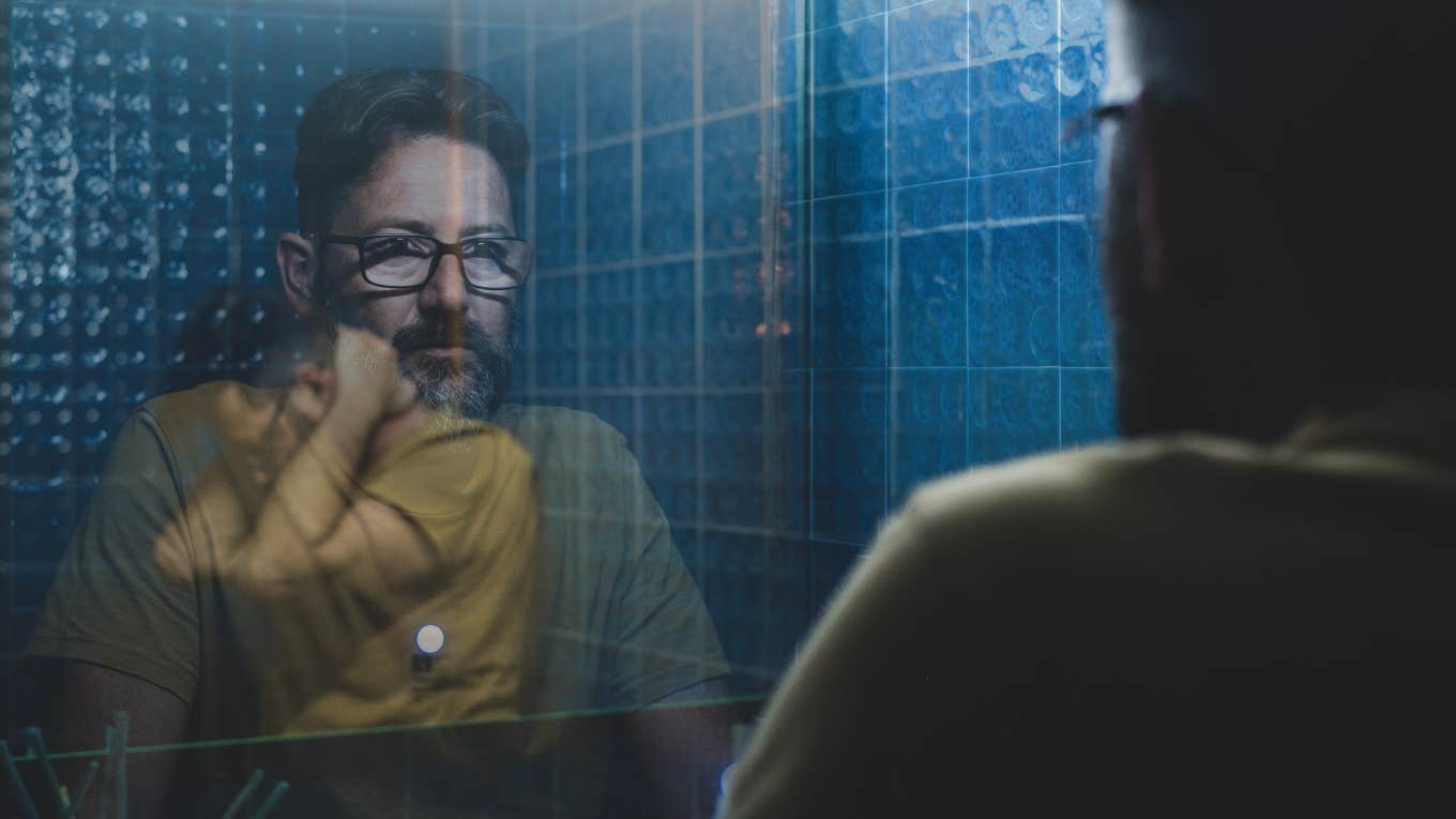 Man confidently staring into mirror, inside tourtored by insecurity 