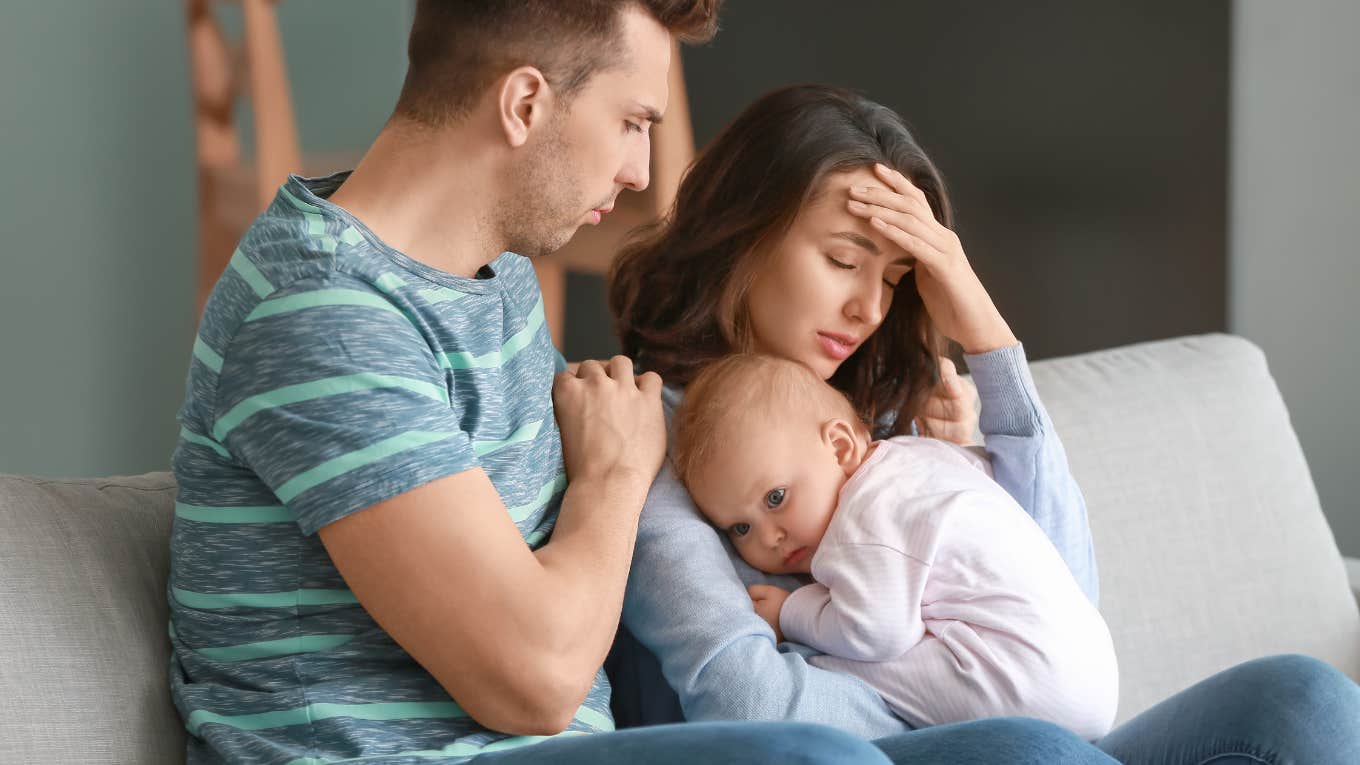 Upset parents holding their young son