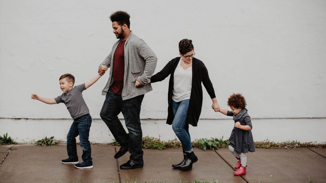 family holding hands on sidewalk