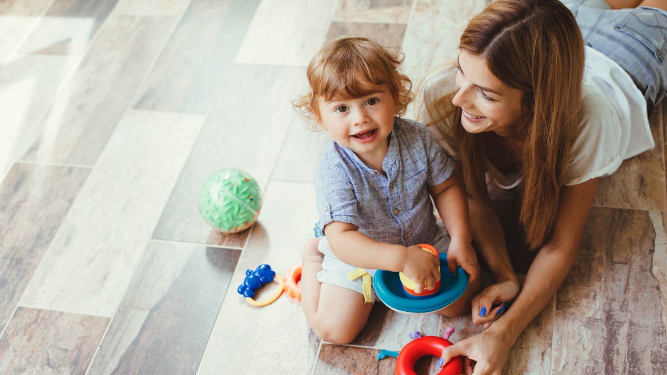 Mom playing with her son with toys on the floor at home