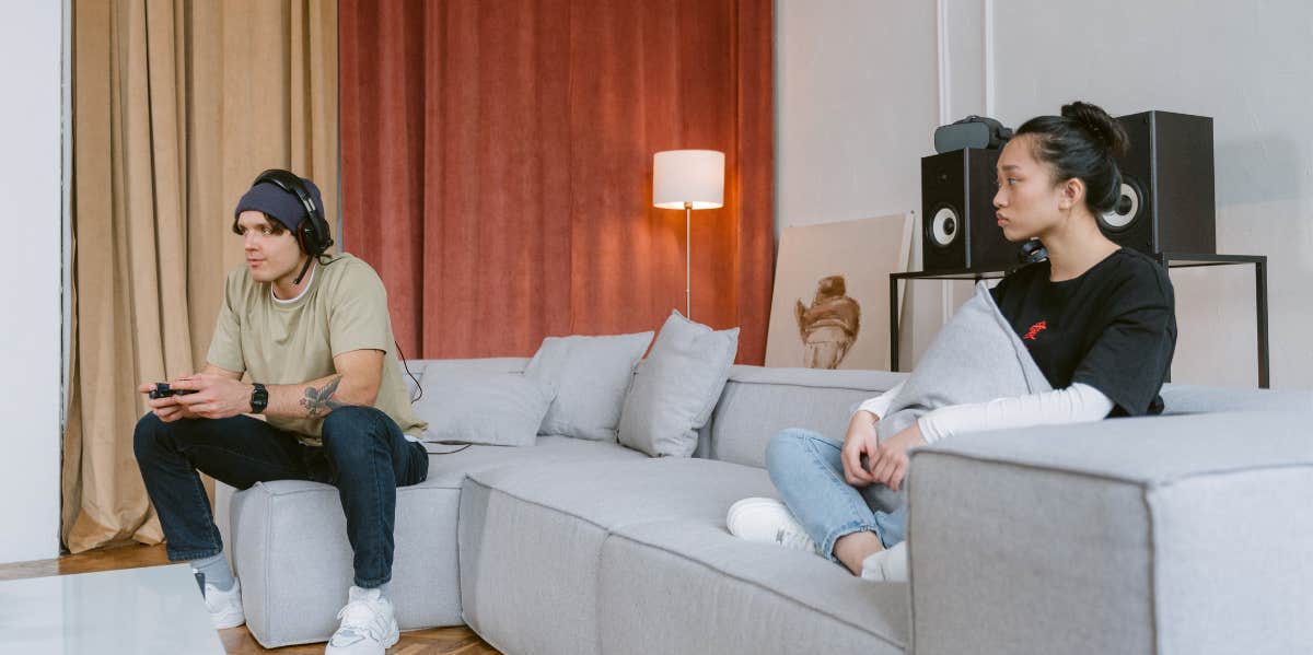 Man playing video games while woman watches 