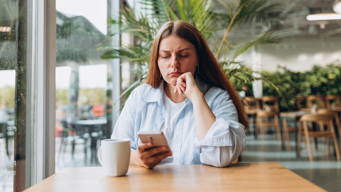 upset woman looking at phone