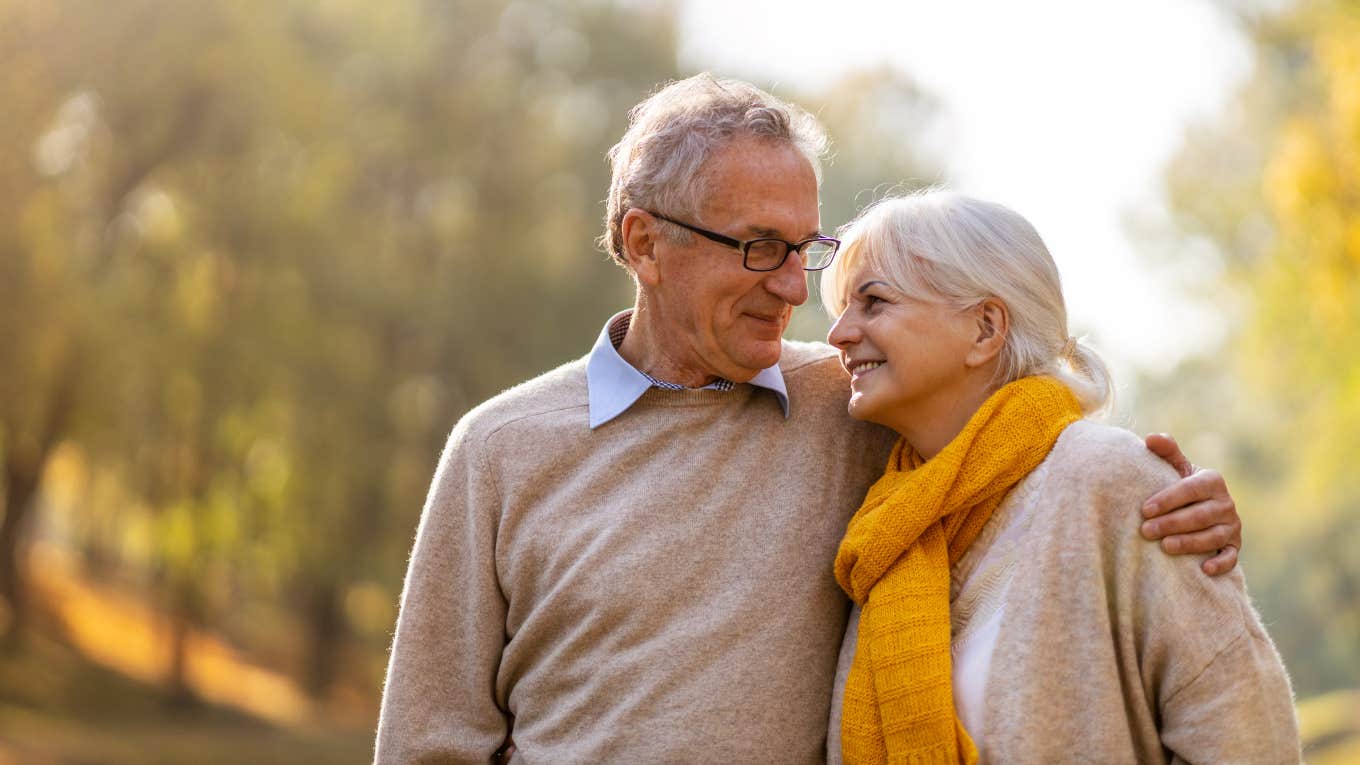 elderly couple hugging outside