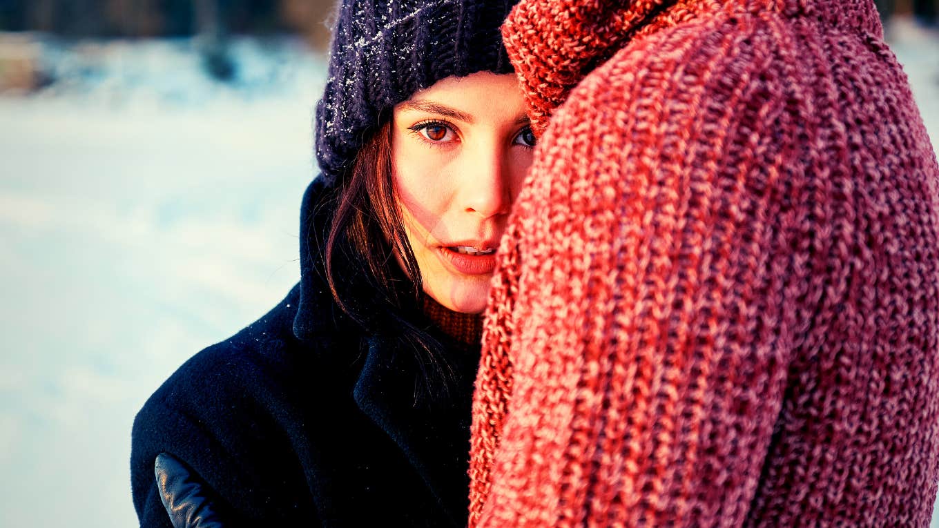 woman hugging man looking sadly at the camera