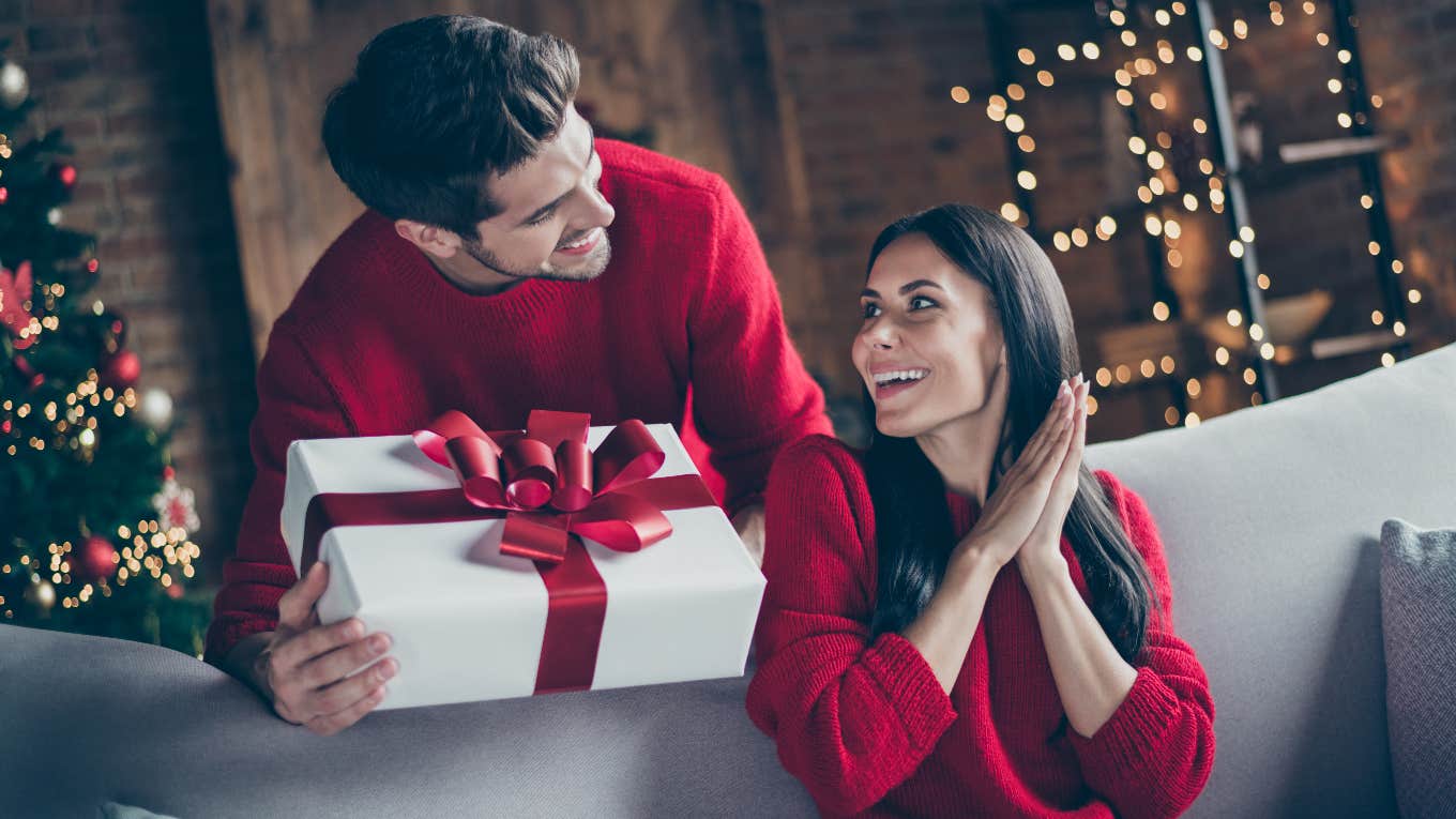 Son gives a Christmas gift to mom. Mom pleasantly surprised and