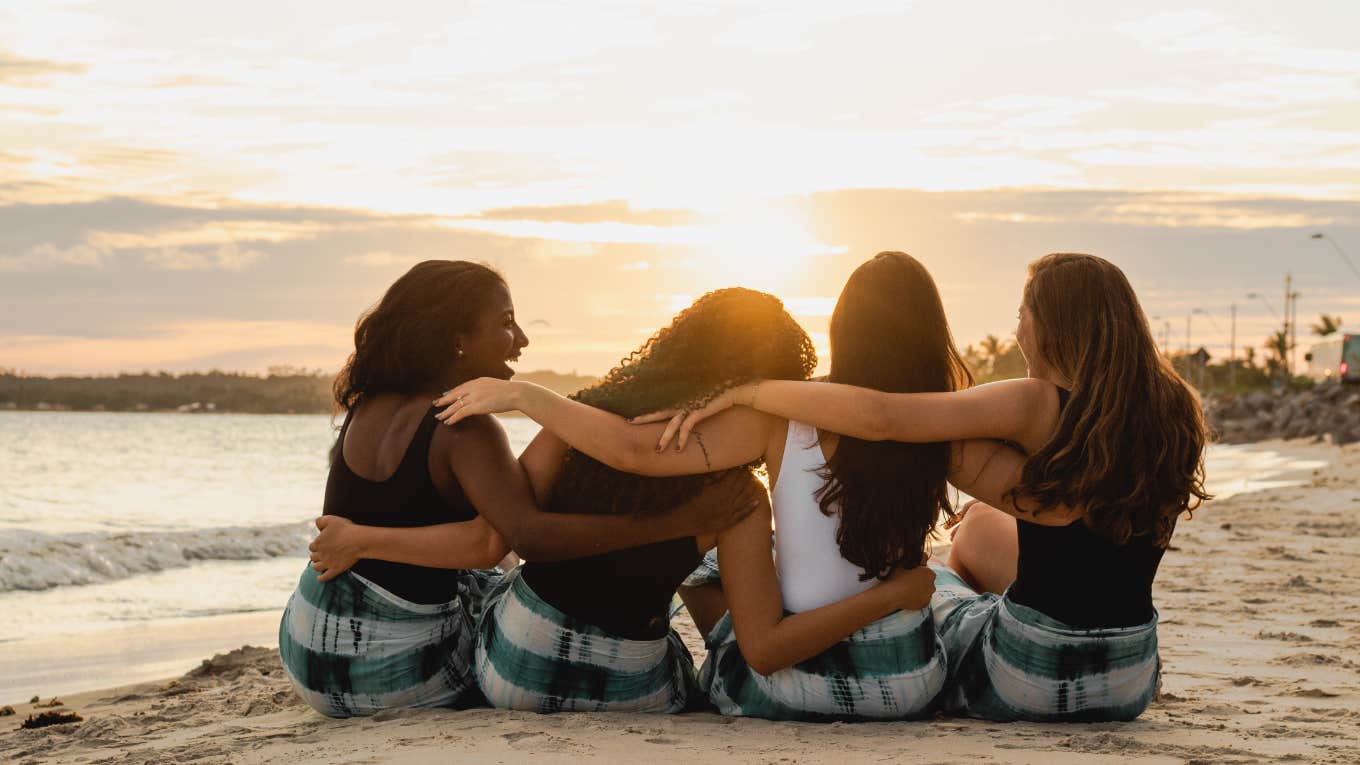 women sit on a beach