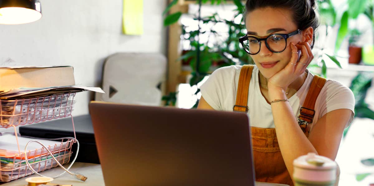 woman in glasses working on laptop