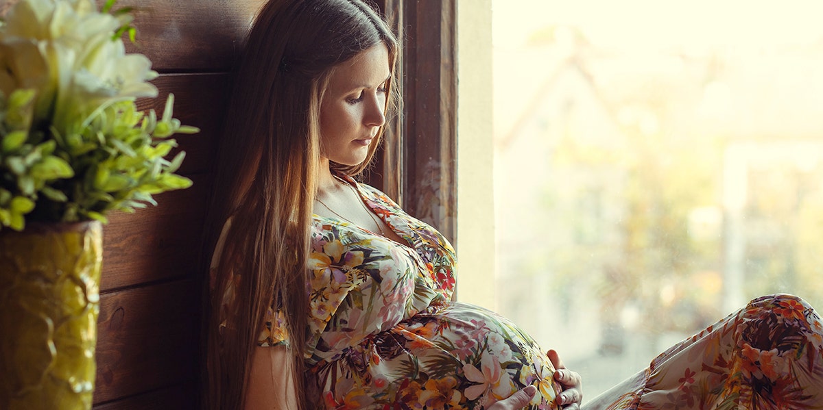 woman cradling pregnant belly