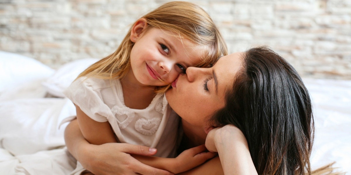 mom kissing daughter