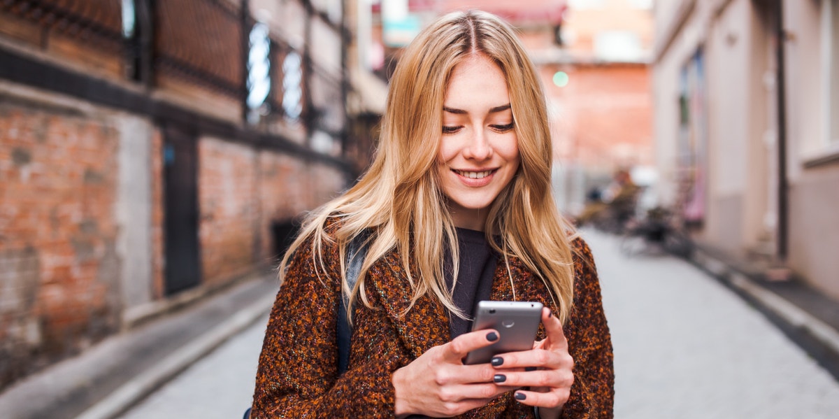 I Found Love On A Hopeless Dating Site And So Can You woman texting on street