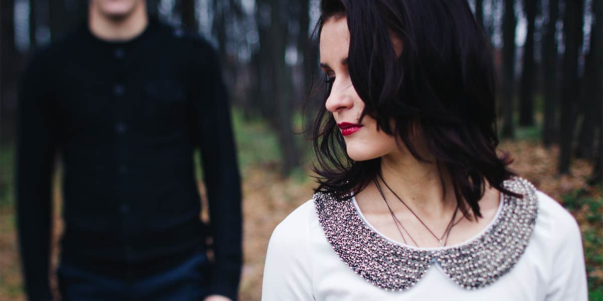 4 Harsh Reasons You Keep Having Emotionally Abusive Relationships woman stuck in bad relationship with boyfriend behind her