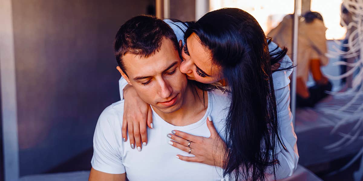 woman kissing man from behind