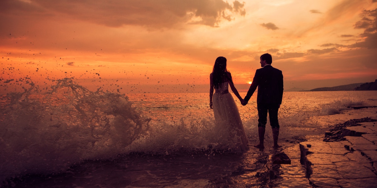 couple holding hands on beach