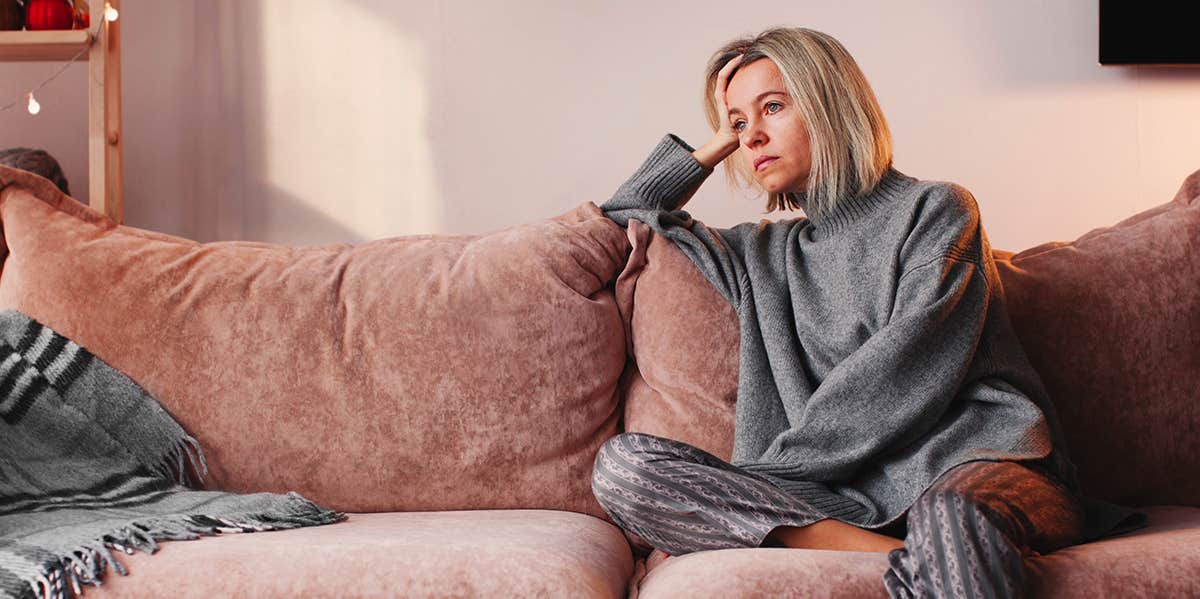 Forget The Other Woman — Your Husband Is To Blame For His Affair sad woman sitting on couch