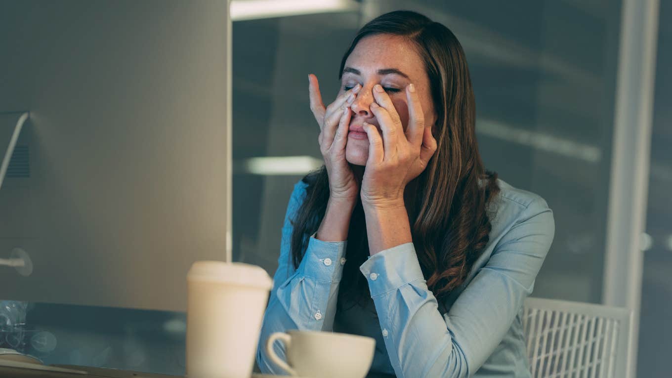 Worker looking stressed out in front of her computer. 