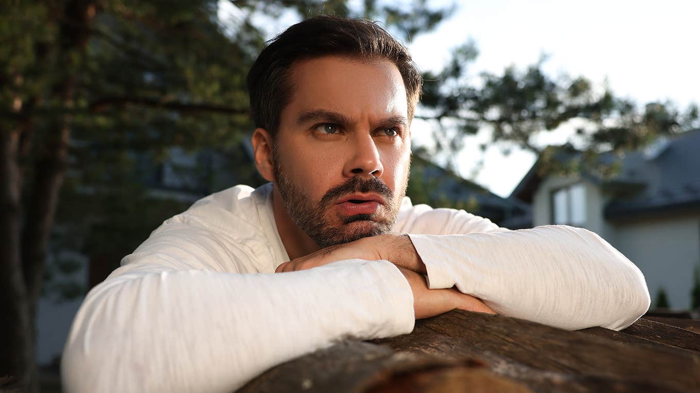 angry man leaning on wood