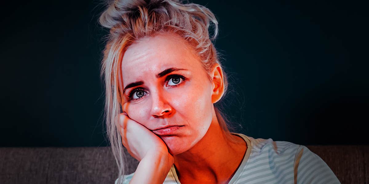 sad lonely woman with hand on cheek