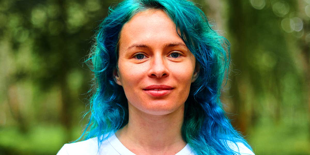 woman with blue hair in the woods