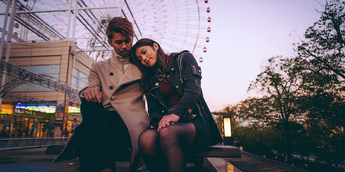 young couple sitting together at amusement park