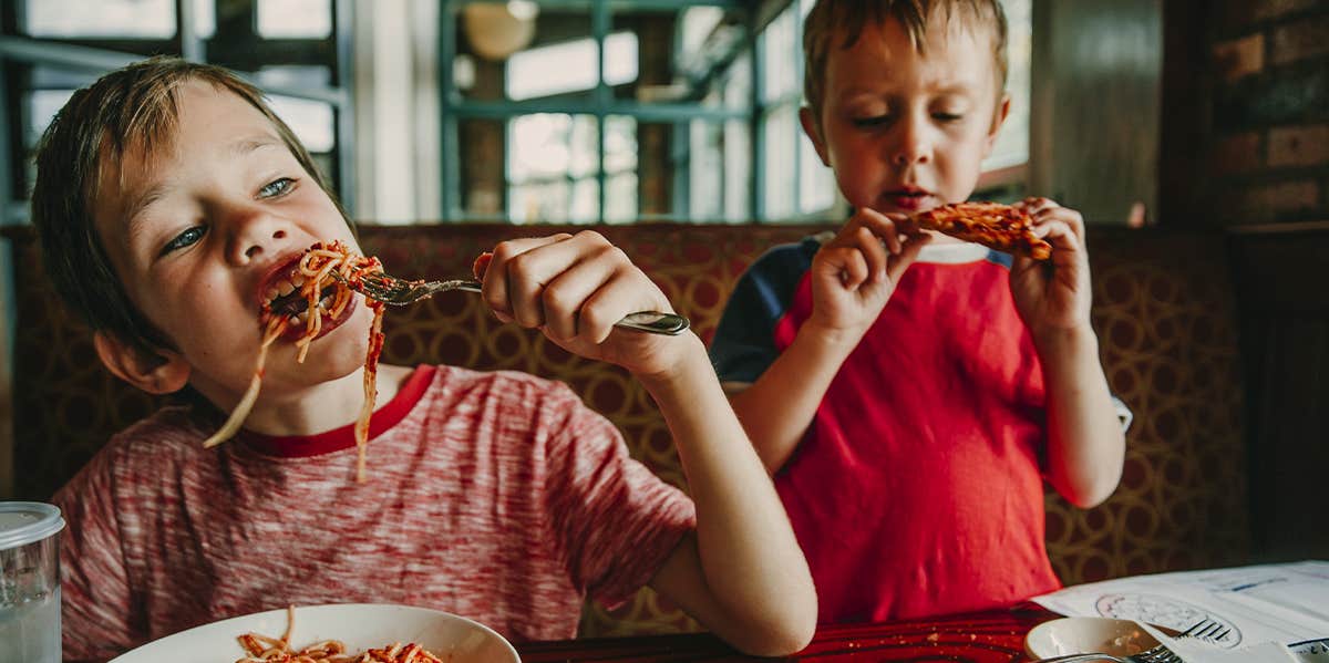 two little boys eating at restaurant