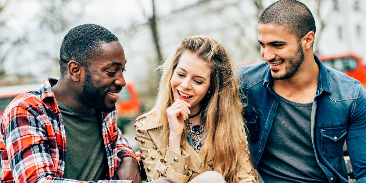 a woman seated between two men who are both interested in her