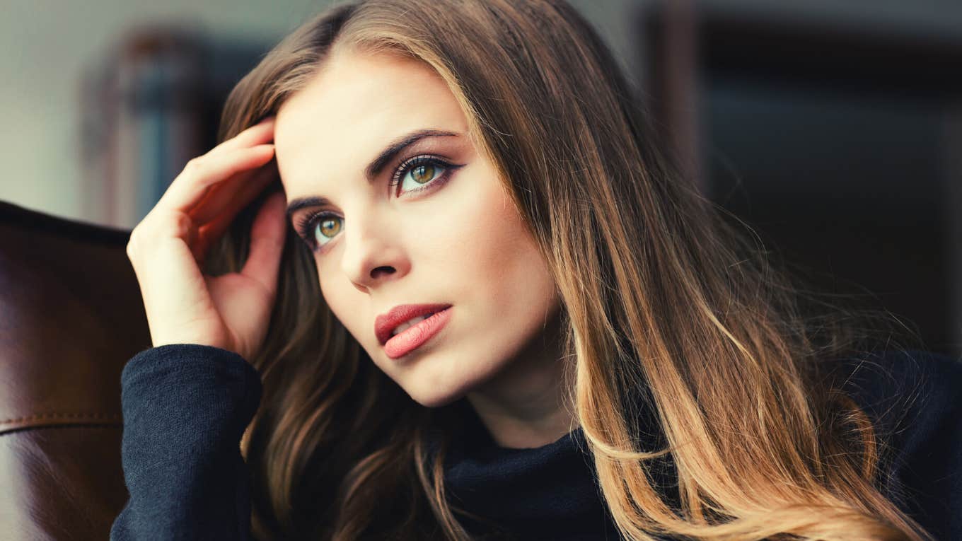 Portrait of attractive thoughtful young woman sitting at home