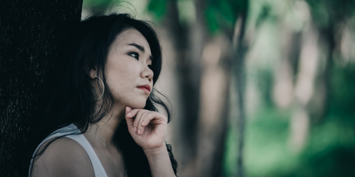 woman sad next to tree