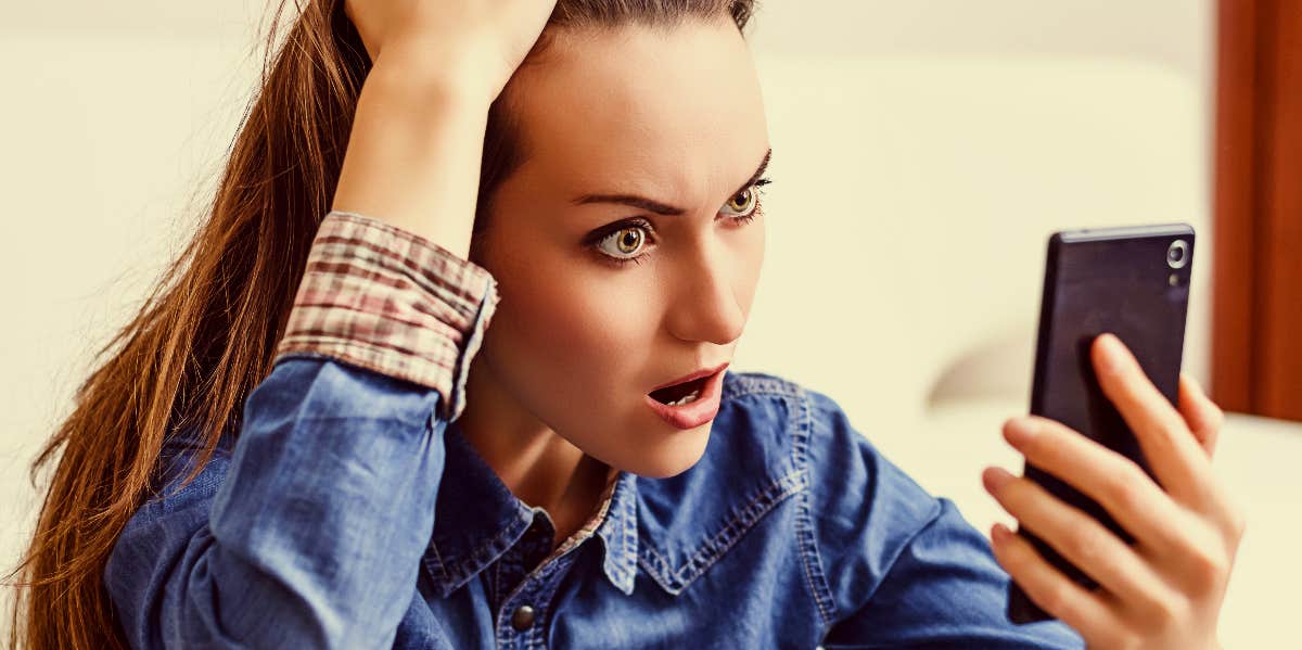 Woman in shock looking at phone.