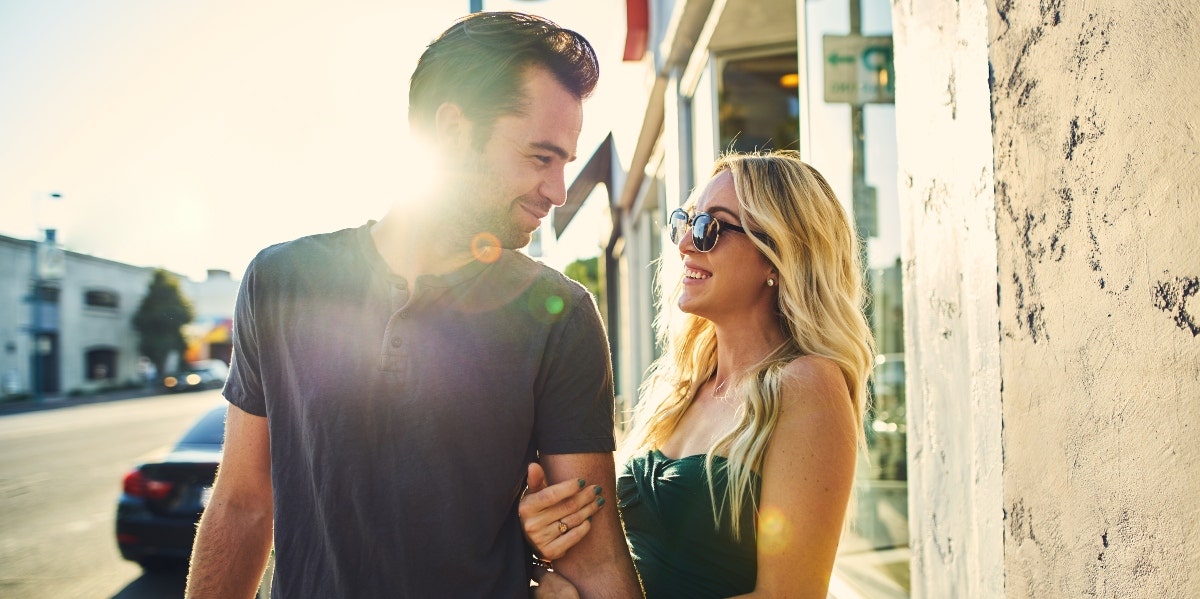 couple smiling at each other on the street