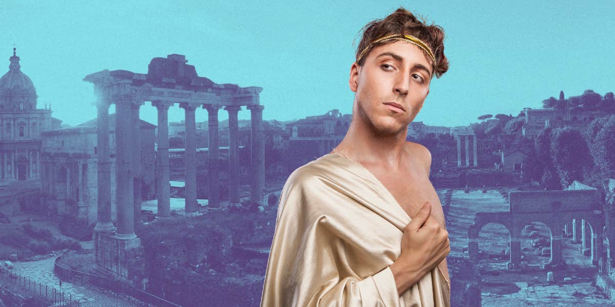 man wearing a toga standing in front of ancient Greece