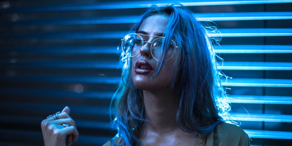 5 Negative INTJ Personality Traits They Try To Hide woman with glasses blue background