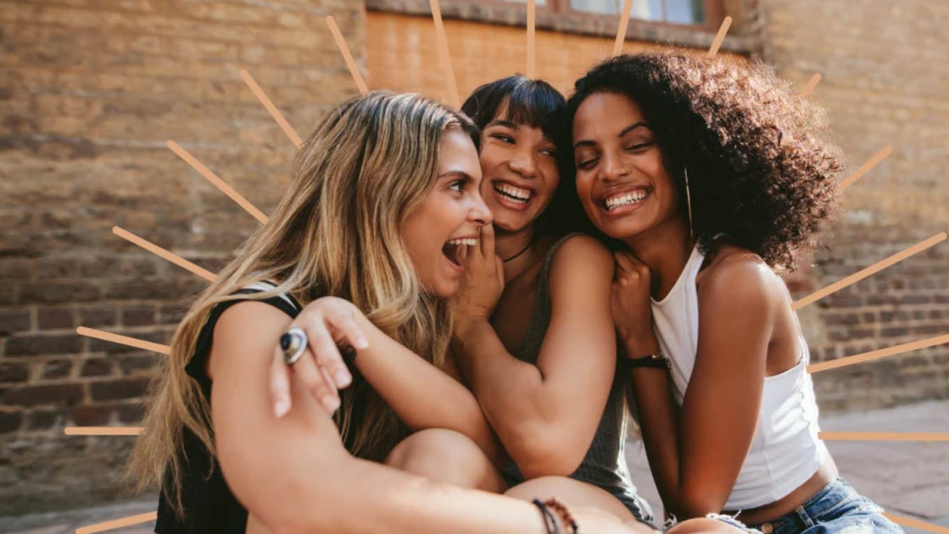 three young women laughing together outdoors 