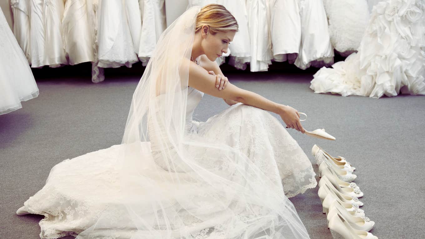 sad woman trying on wedding dresses