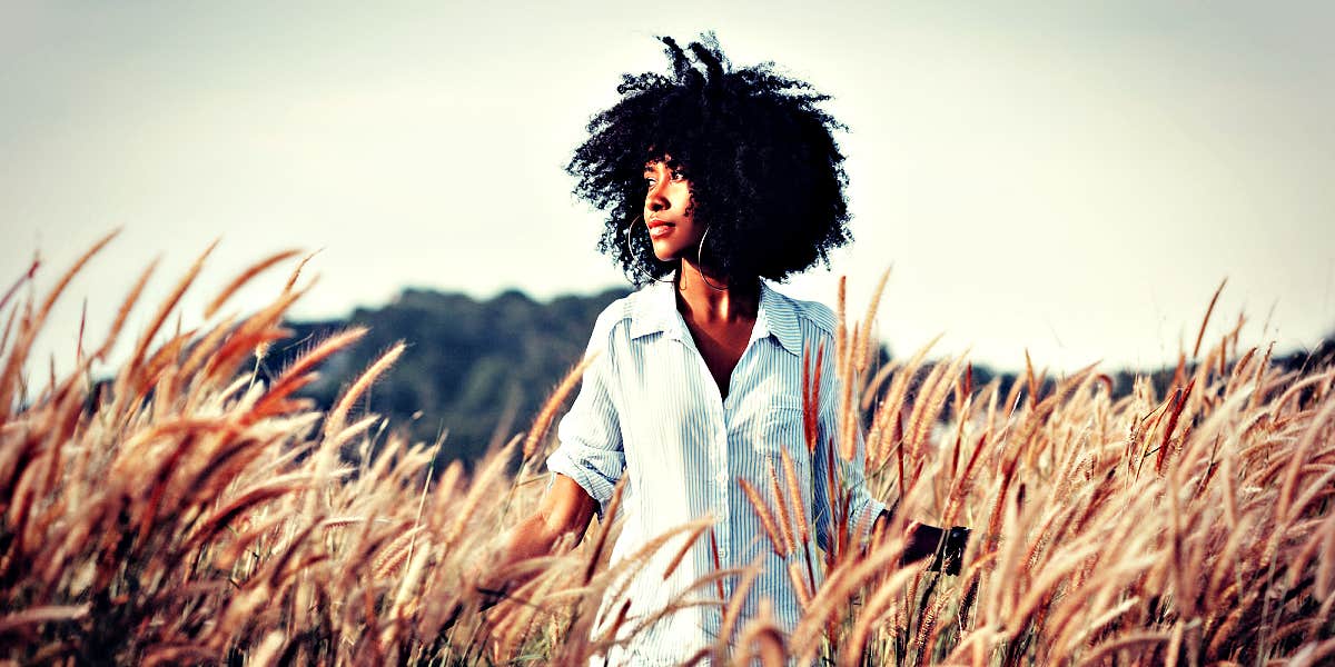 woman standing peacefully in a wheat field